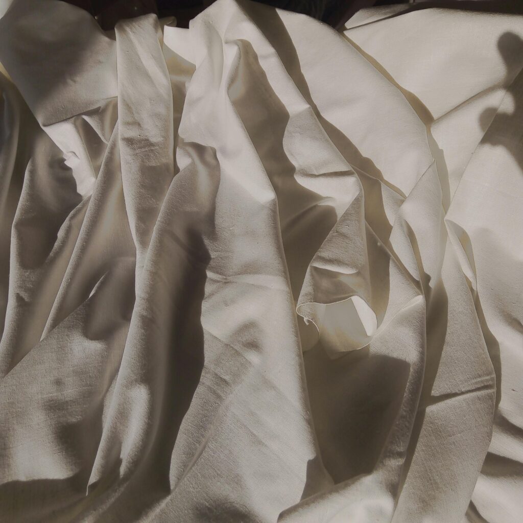 Abstract arrangement of white fabric with soft shadows, creating a minimalist aesthetic.